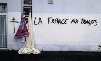 Graffiti avec texte "La France aux Français" sur un mur blanc.