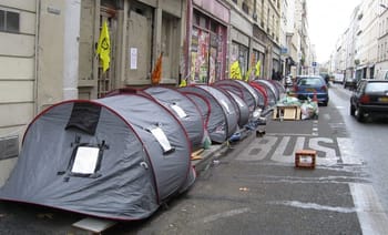 Tentes de sans-abri alignées sur une rue de Paris.