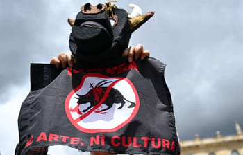 Personne tenant une bannière anti-corrida avec un taureau barré.