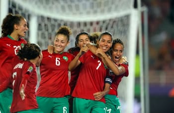 Joueuses marocaines de football célébrant un but lors d'un match.