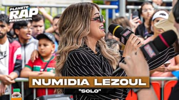 Numidia Lezoul lors d'une interview avec microphone en public.
