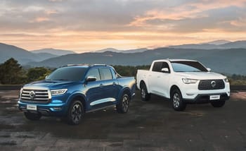 Deux pick-up Great Wall en plein air avec paysage montagneux au coucher du soleil.