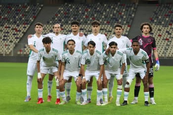 Groupe de joueurs de football en uniforme blanc sur le terrain.