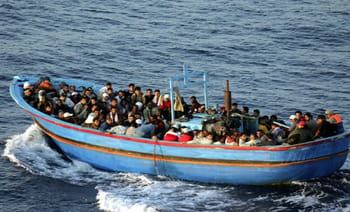 Groupe de migrants à bord d'une embarcation en mer Méditerranée.