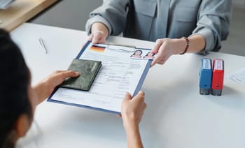 Personne remettant un formulaire de demande de visa à un agent.