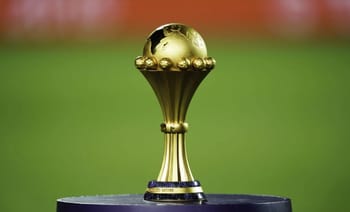 Trophée doré de la CAN 2025 sur fond vert.