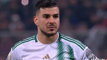 Mercato de folie! Pour un certain Zakaria Draoui, Mobilis et Sontrach sont prêts à claquer des millions de centimes Football, joueur en maillot blanc et vert, concentration intense.