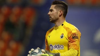 Gardien de but en action portant maillot jaune lors d'un match de football.