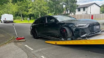 Voiture noire endommagée après un accident de circulation.