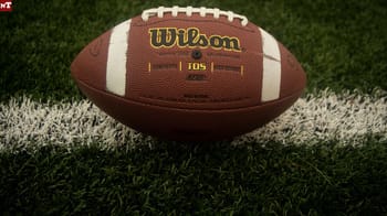 Ballon de rugby Wilson sur terrain en herbe.