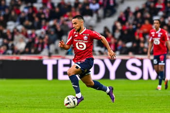 Footballeur en mouvement avec le ballon sur le terrain.