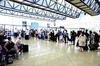 Passagers à l'aéroport d'Alger avec bagages et files d'attente.