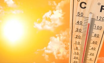 Thermomètre indiquant une forte chaleur sous un ciel ensoleillé.
