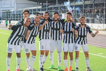 Groupe de joueurs de football algérien célébrant leur victoire.