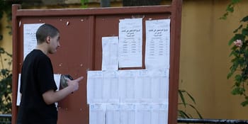 Jeune étudiant vérifiant ses résultats du Bac sur un tableau d'affichage.