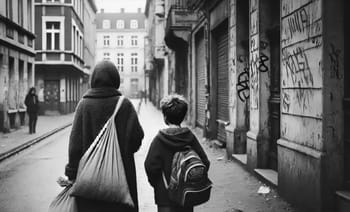 Femme et enfant migrés marchant dans une rue urbaine en France.