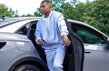 Kylian Mbappé sort d'une voiture avec un sac à dos.
