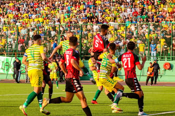 Joueurs de football en action lors d'un match intense en plein air.