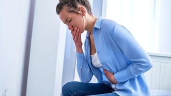 Femme souffrant de douleurs abdominales, symptôme d'intoxication alimentaire.