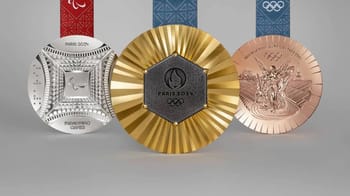 Trois médailles olympiques de Paris 2024 avec rubans colorés.