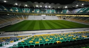 Stade Hocine Aït Ahmed avec terrain de football et sièges modernes.