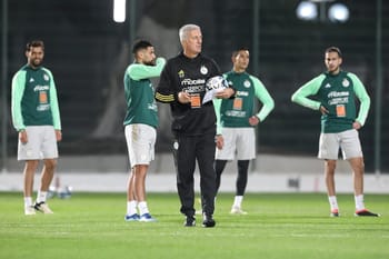 Entraîneur de football avec ballon et équipe lors d'une séance d'entraînement.