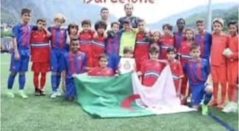 Lamine Yamal souriant avec drapeau algérien lors d'un match de football.