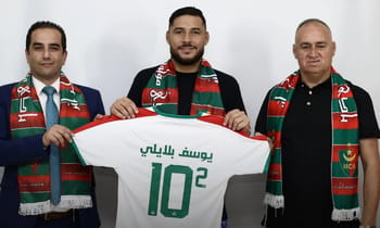 Youcef Belaili pose avec ses dirigeants portant écharpes du MC Alger.