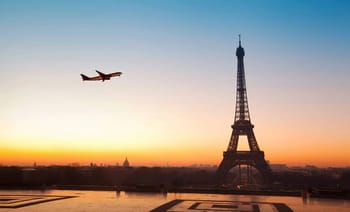 Avion volant près de la Tour Eiffel au crépuscule à Paris.