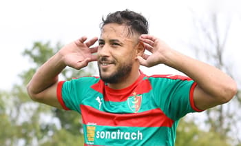 Youcef Belaili lors d'un entraînement ou match, souriant et concentré.