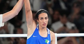 Femme athlète en compétition de boxe, levant le bras.