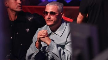 DJ Snake portant des lunettes de soleil et une veste grise lors d'une apparition publique.