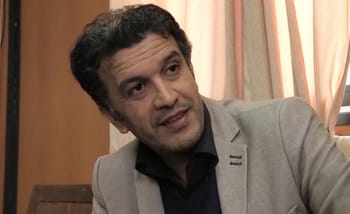 Fethi Ghares en discussion dans un cadre intérieur.