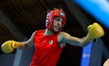 Boxeuse algérienne portant casque et gants jaunes en combat.