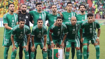Groupe de joueurs de football en uniforme vert sur le terrain.