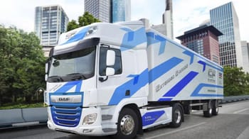 Camion 100 % électrique présenté dans un environnement urbain moderne.