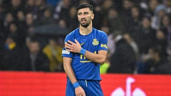 Amine Amoura en maillot de football bleu sur le terrain.