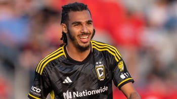 Mohamed Farsi, joueur de football algérien, souriant sur le terrain.