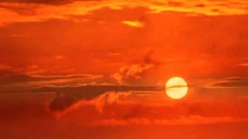 Coucher de soleil avec ciel orange et soleil brillant.