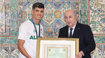 Athlète algérien recevant une médaille lors d'une cérémonie officielle.