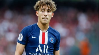 Adil Aouchiche, joueur de football en maillot PSG, sur le terrain.