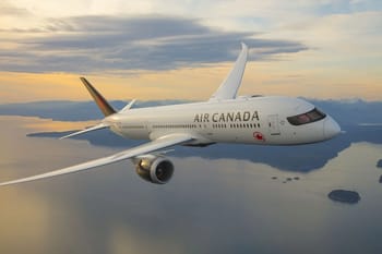 Avion Air Canada survole l'océan avec un ciel nuageux en arrière-plan.