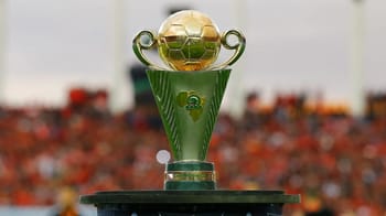 Trophée de la Coupe de la CAF avec un fond de stade rempli de spectateurs.