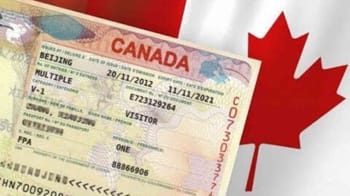 Visa de visiteur canadien avec drapeau du Canada en arrière-plan.