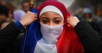 Femme voilée portant un masque et un drapeau français.