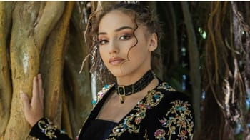 Jeune femme en tenue traditionnelle algérienne dans la nature.