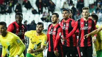 Joueurs de l'USM Alger et de l'équipe adverse sur le terrain de football.
