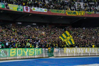 Foule de supporters de la JS Kabylie avec drapeaux et banderoles dans le stade.