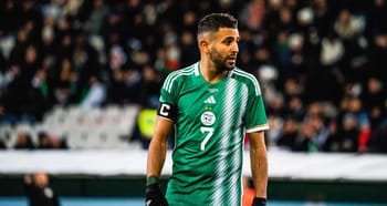 Riyad Mahrez portant le maillot de l'Algérie, en pleine action sur le terrain.