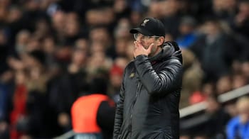 Riyad Mahrez en pleine réflexion sur le terrain de football.